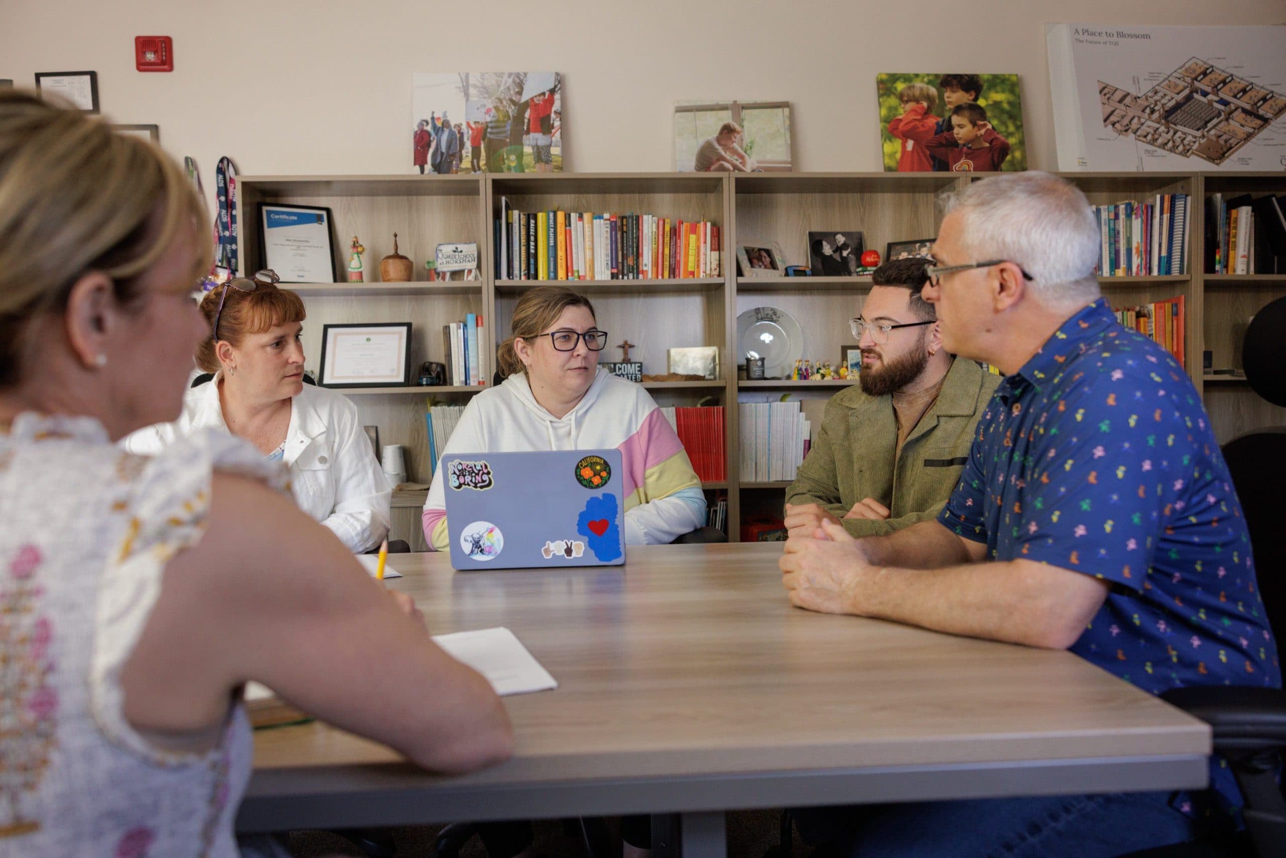 Staff members meeting around a table