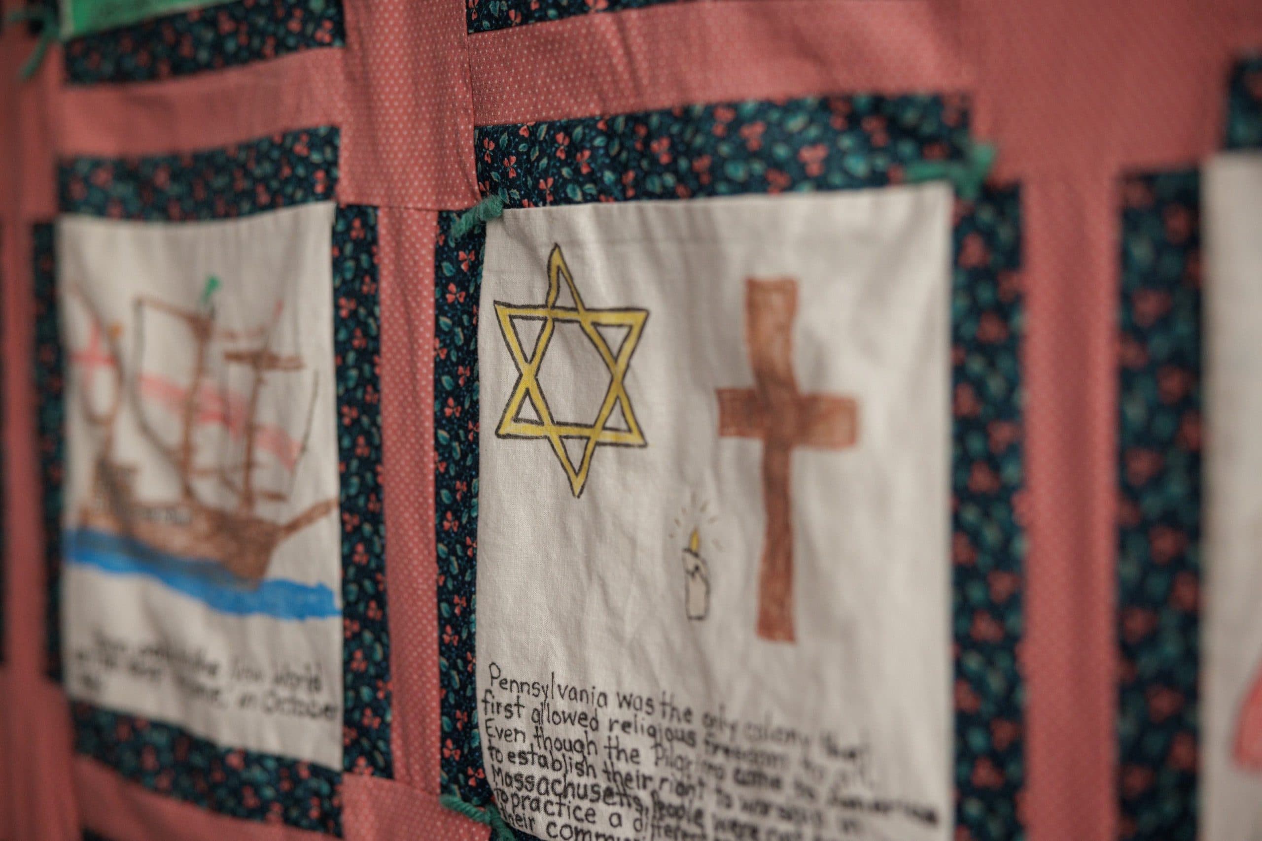 Student-made quilt panel with interfaith symbols