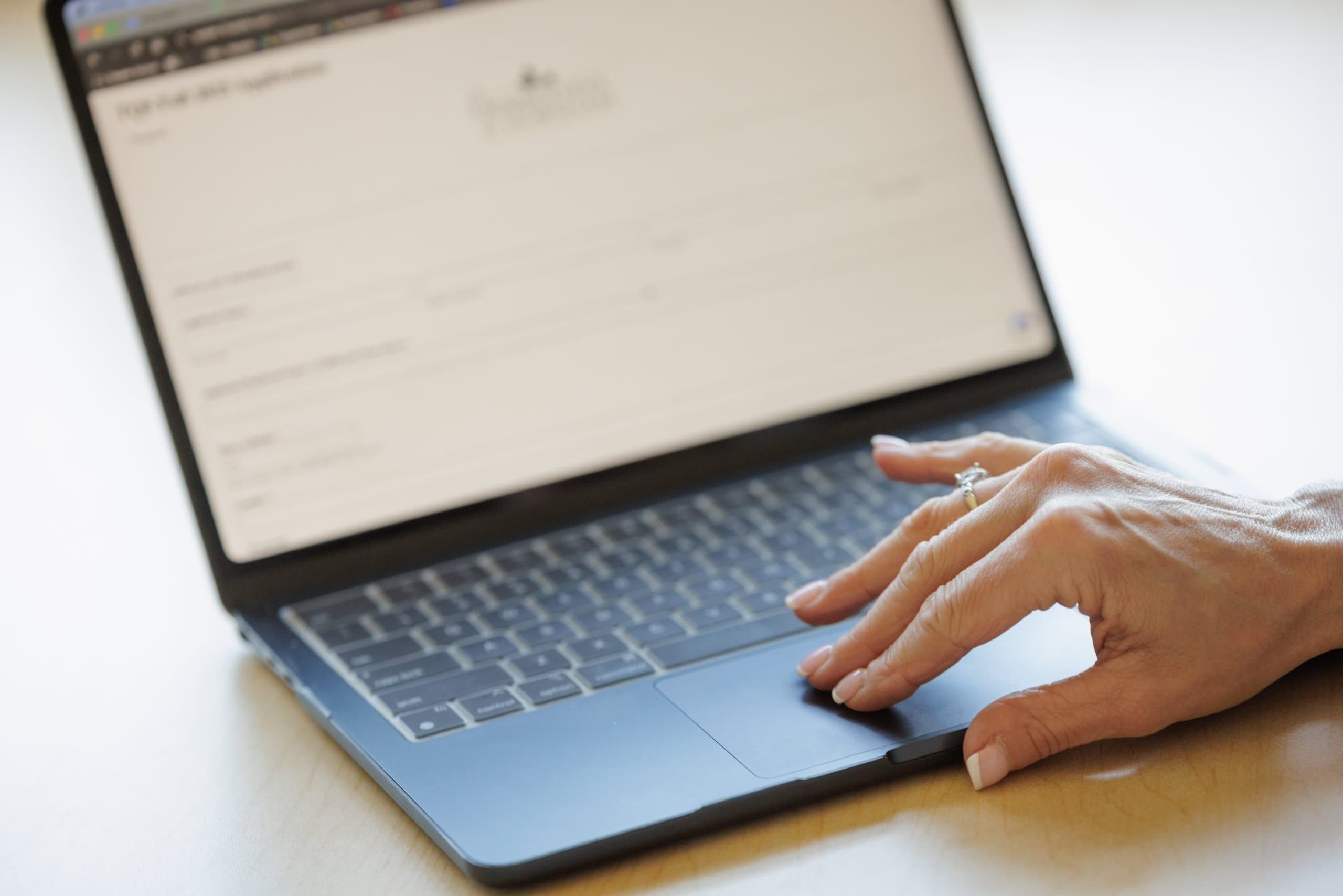 Hands typing on a laptop