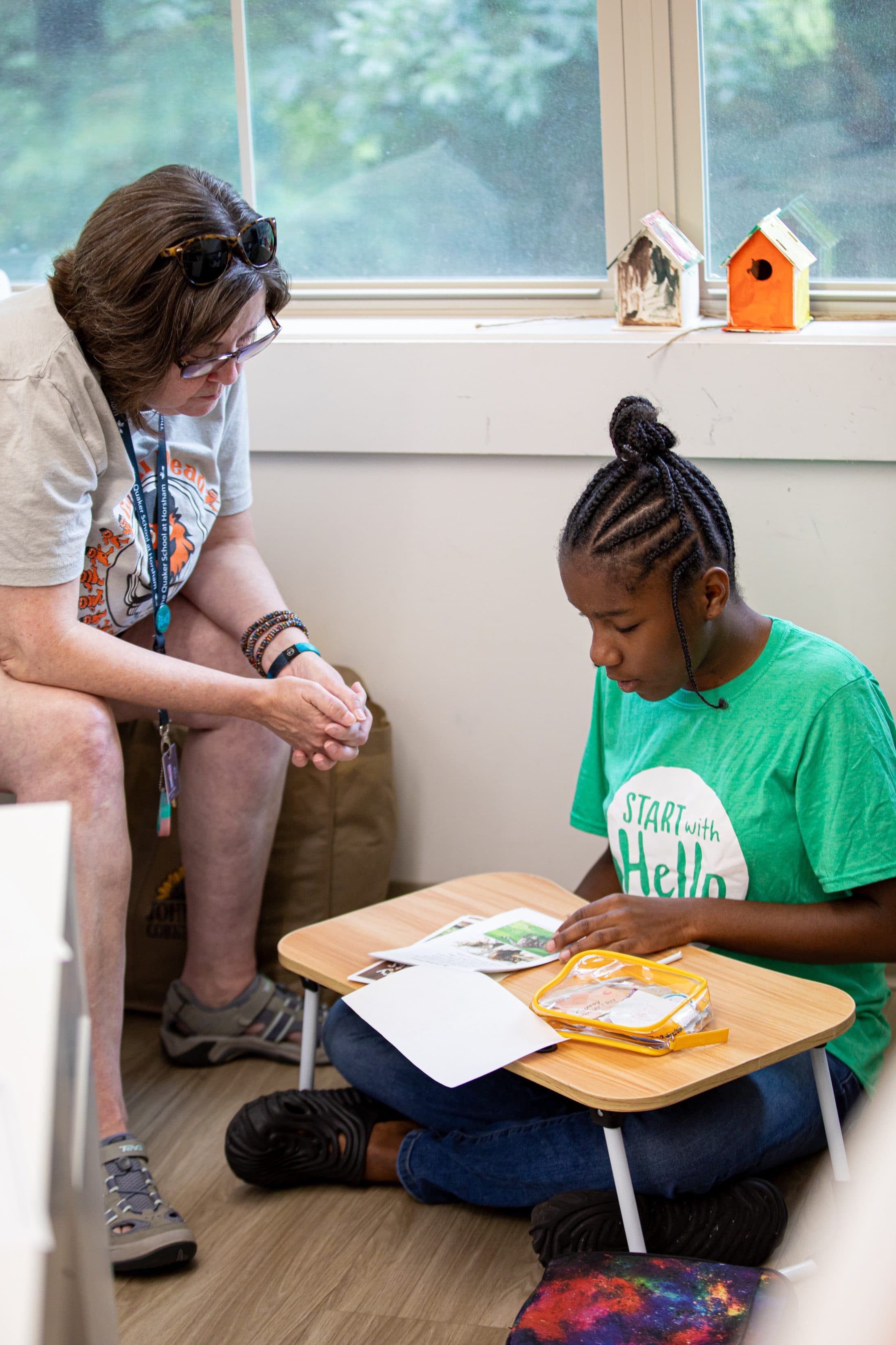 Staff member assisting a student with a hands-on activity