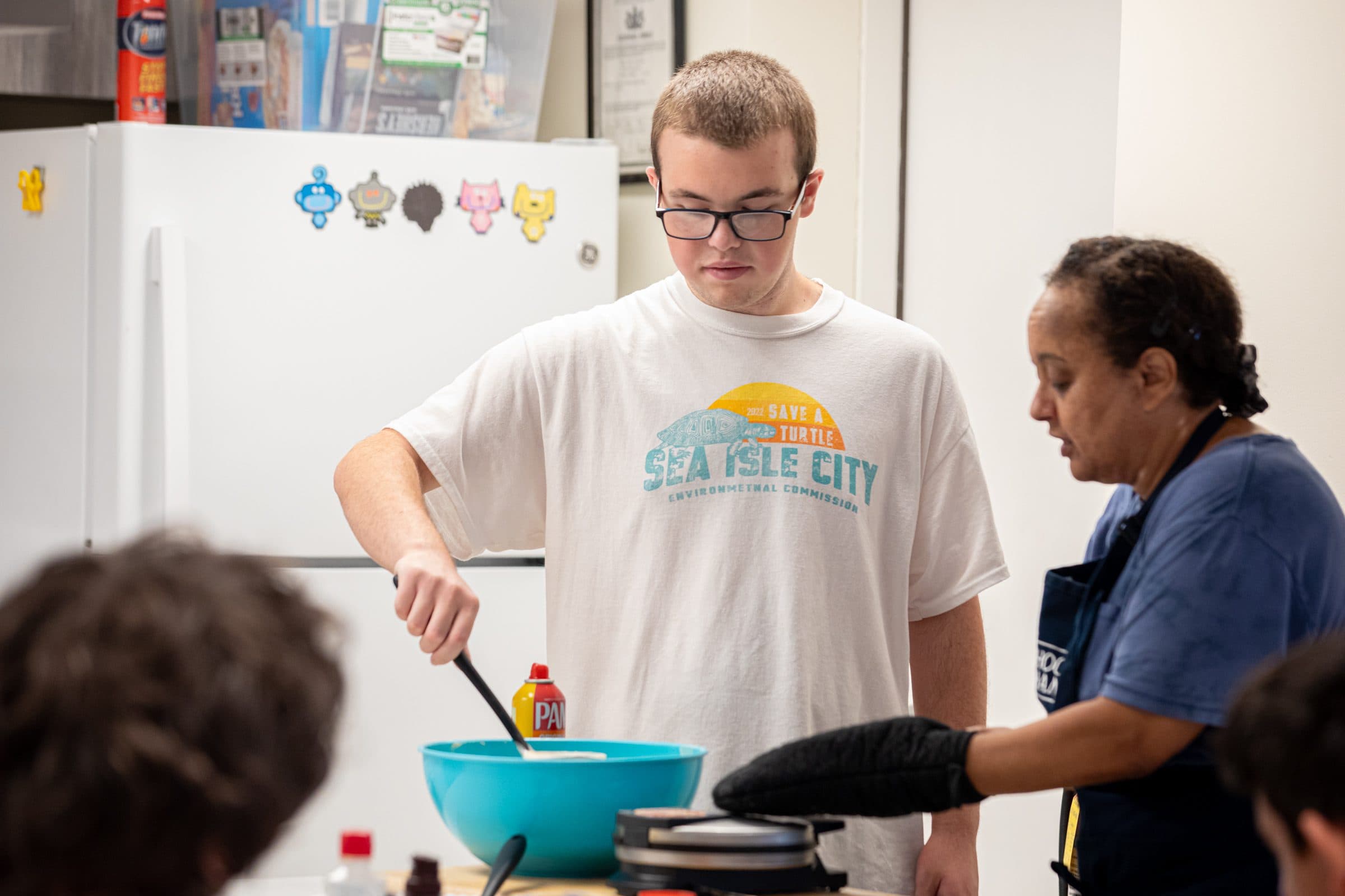 Student and staff working together in a cooking class