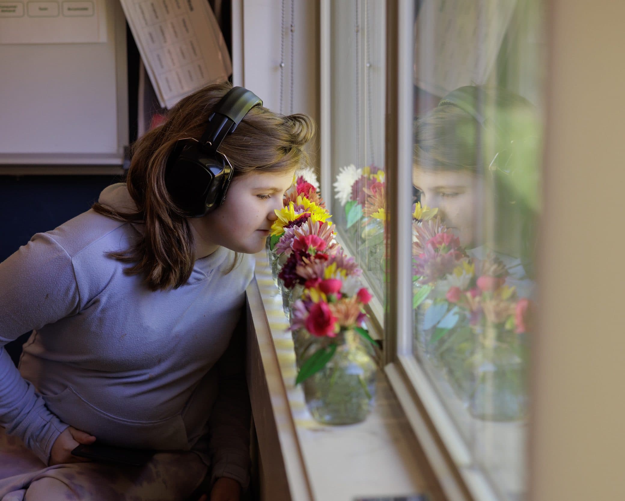 Student wearing headphones near a decorated window
