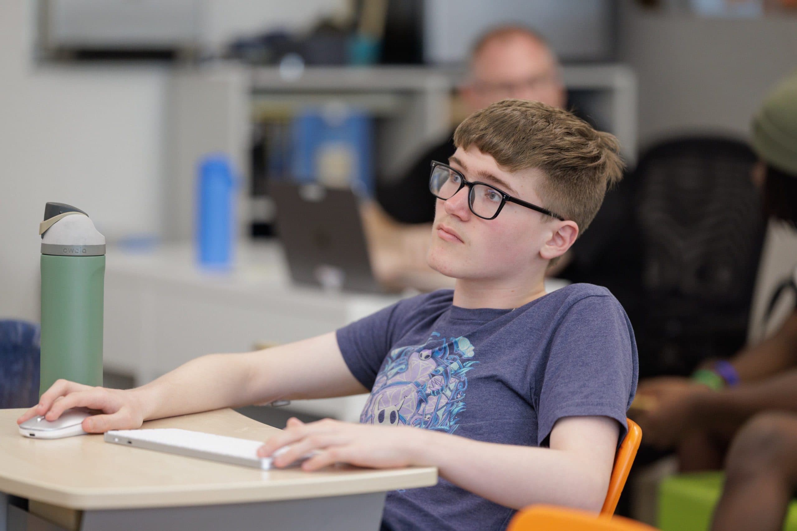 Student listening at a classroom desk