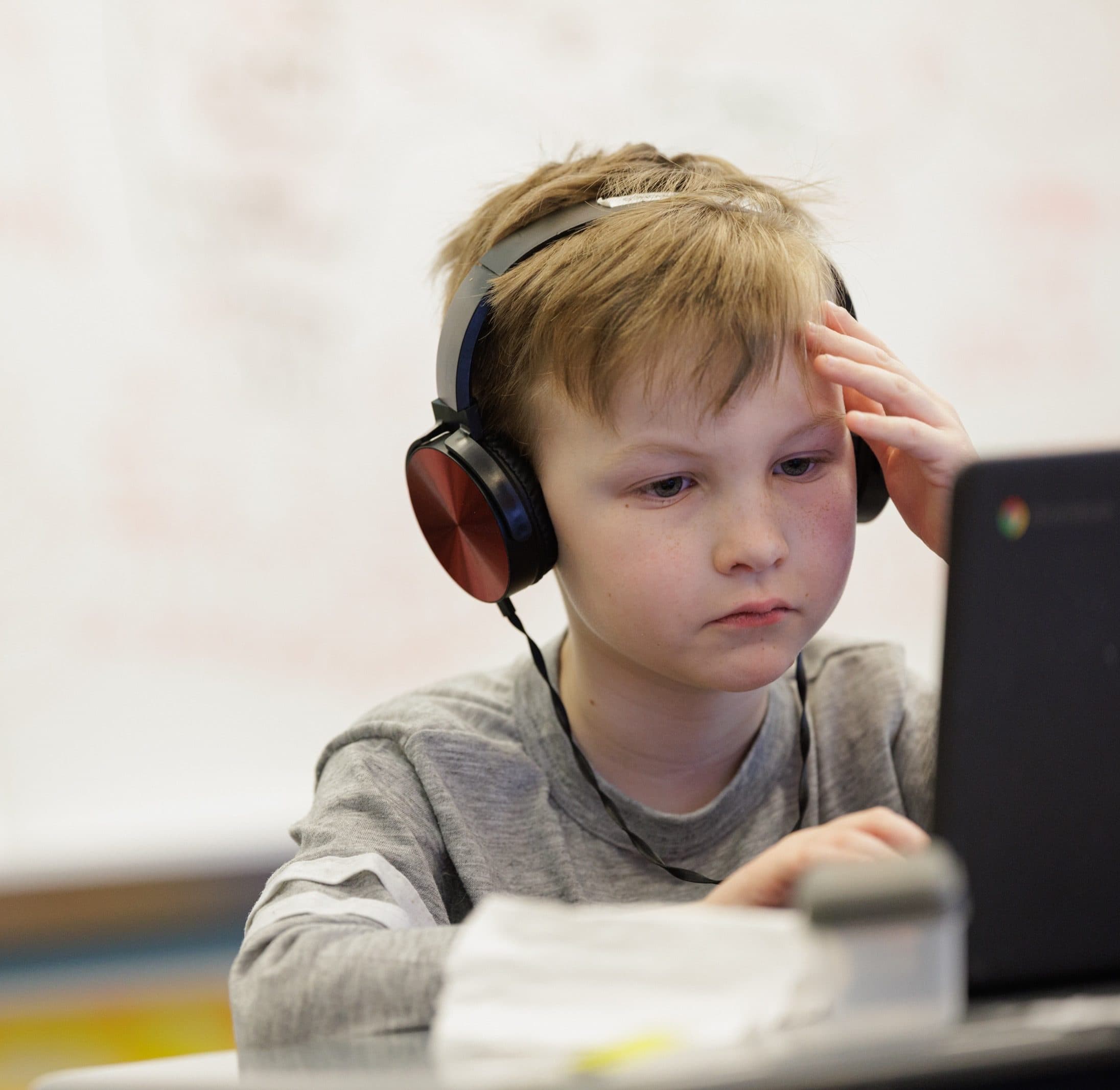 Student wearing headphones while using a laptop