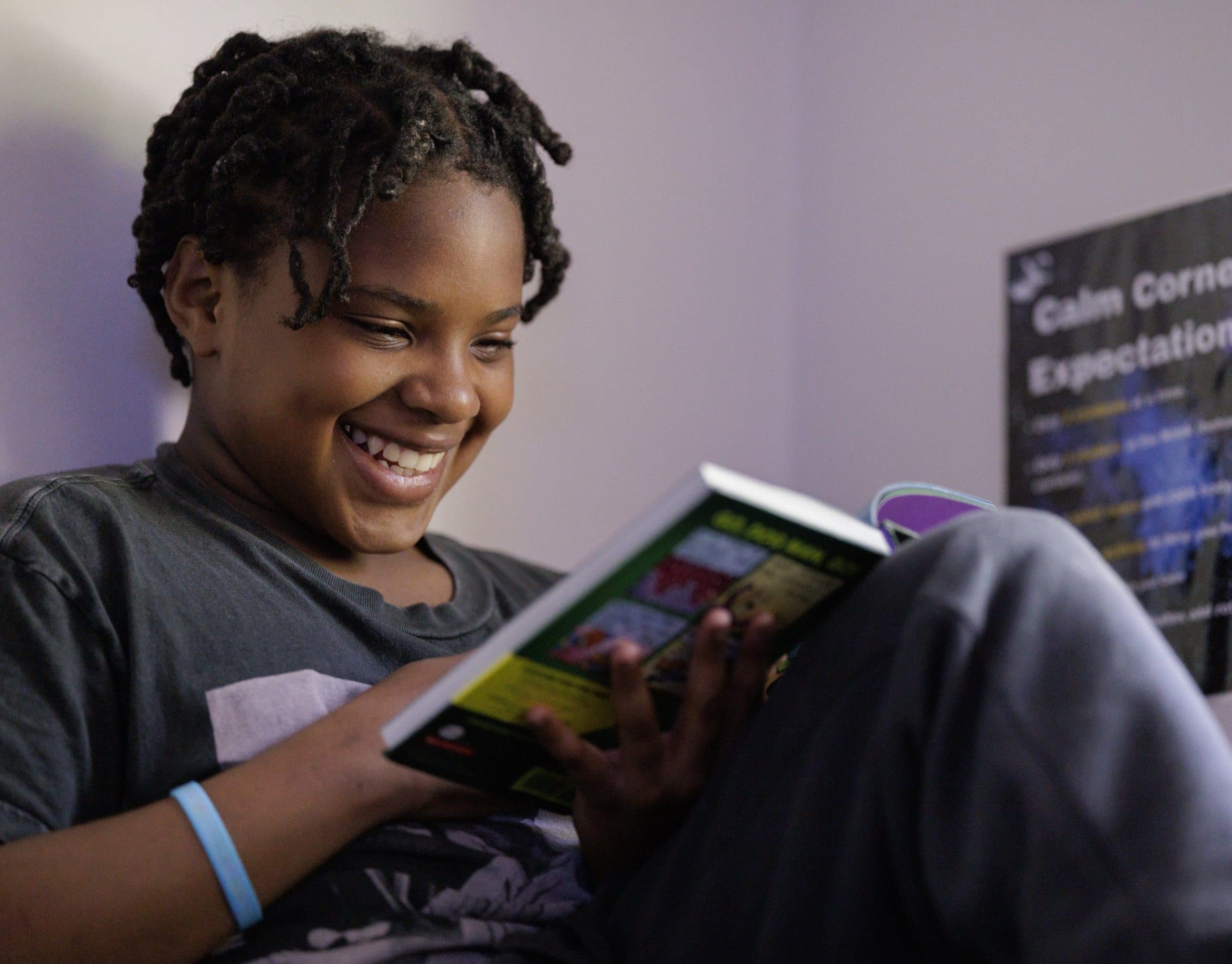 Student smiling while reading in a calm space