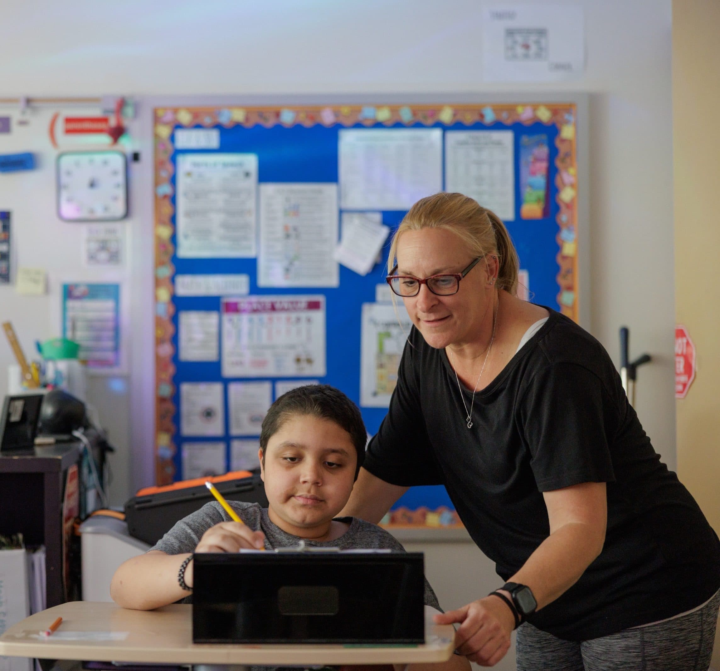 Teacher helping a student with a classroom exercise