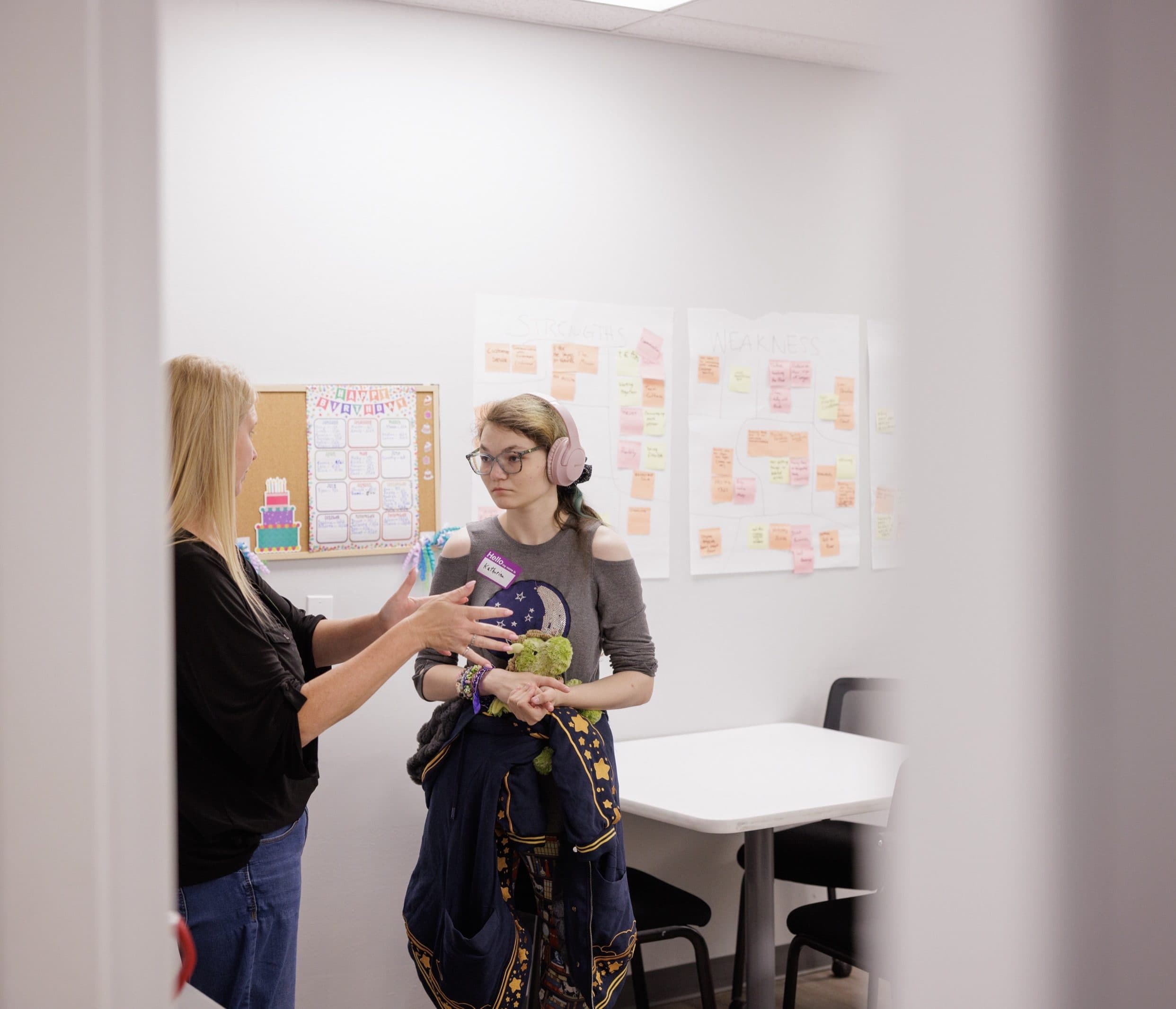 Teacher speaking to a student in a classroom