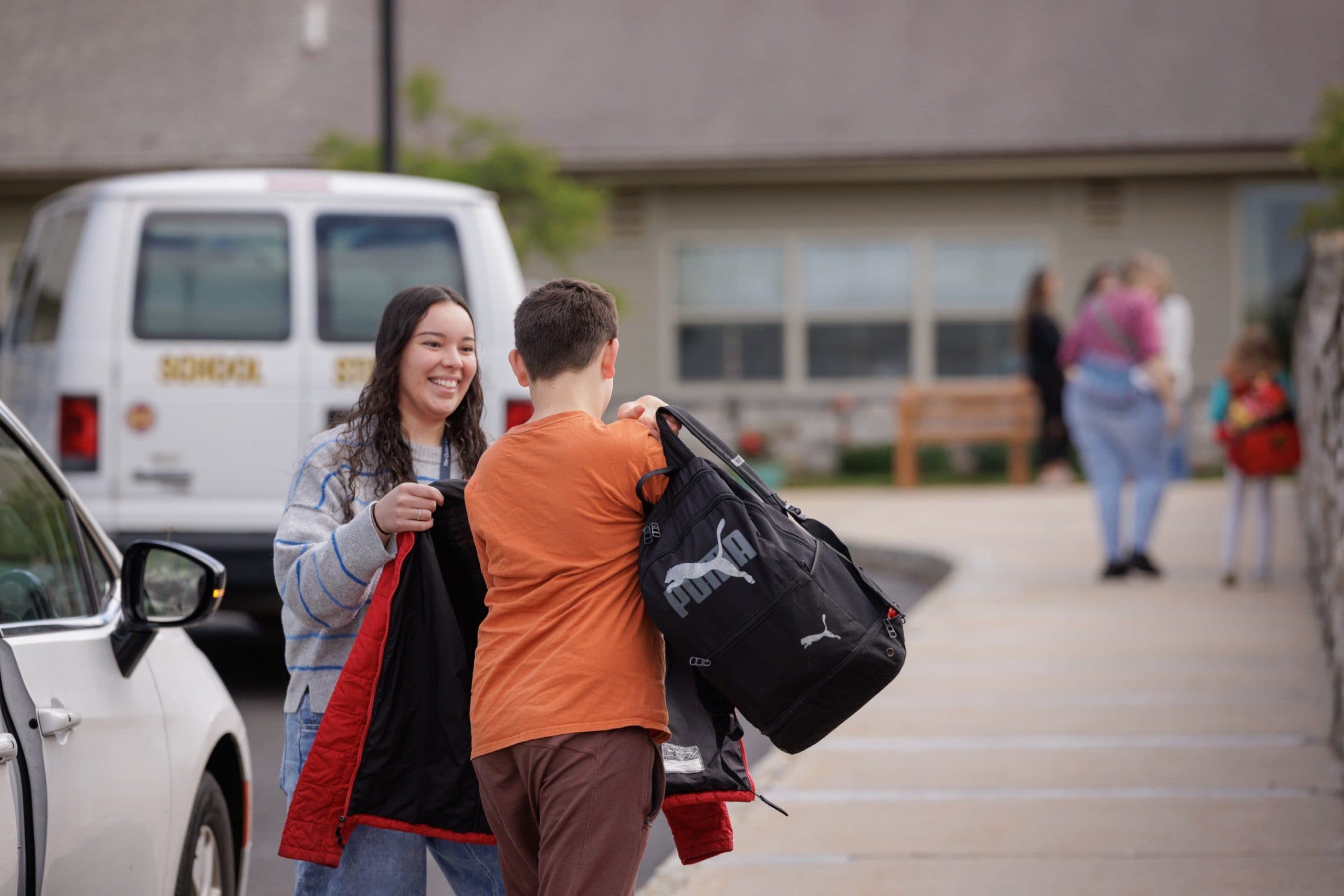 Staff member greeting a student on arrival