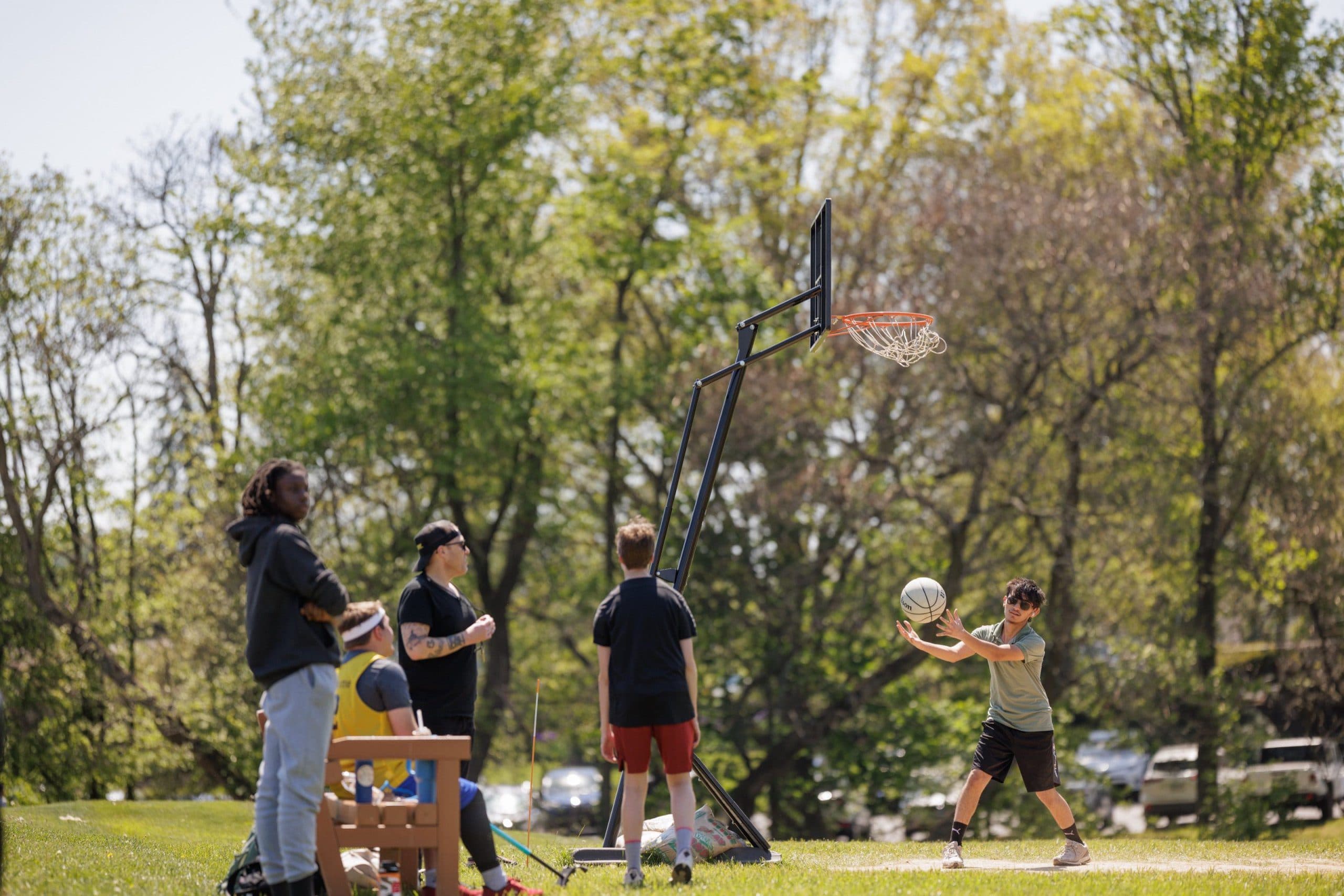 Students playing basketball outdoors during a movement activity