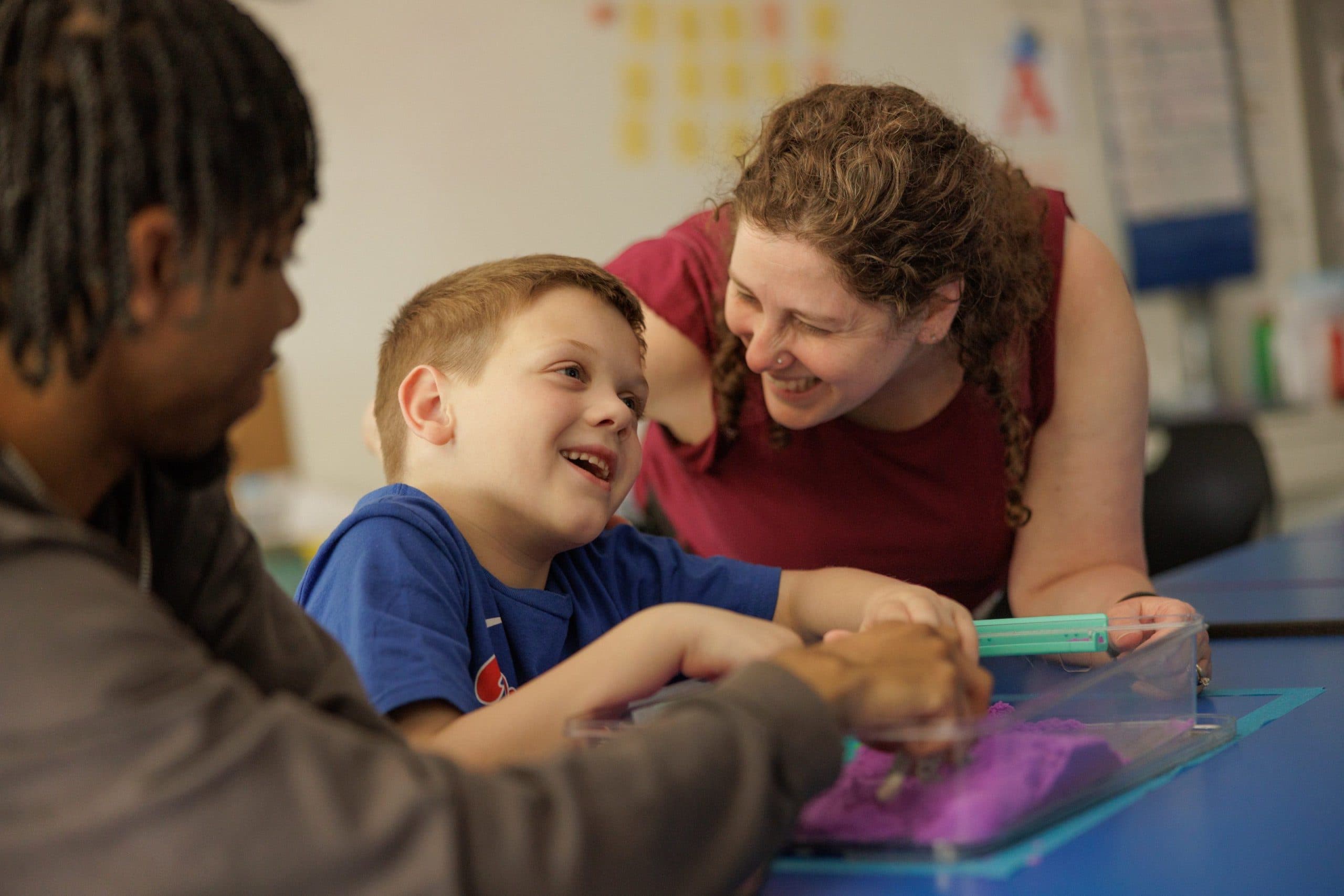 Teacher and student laughing sensory classroom
