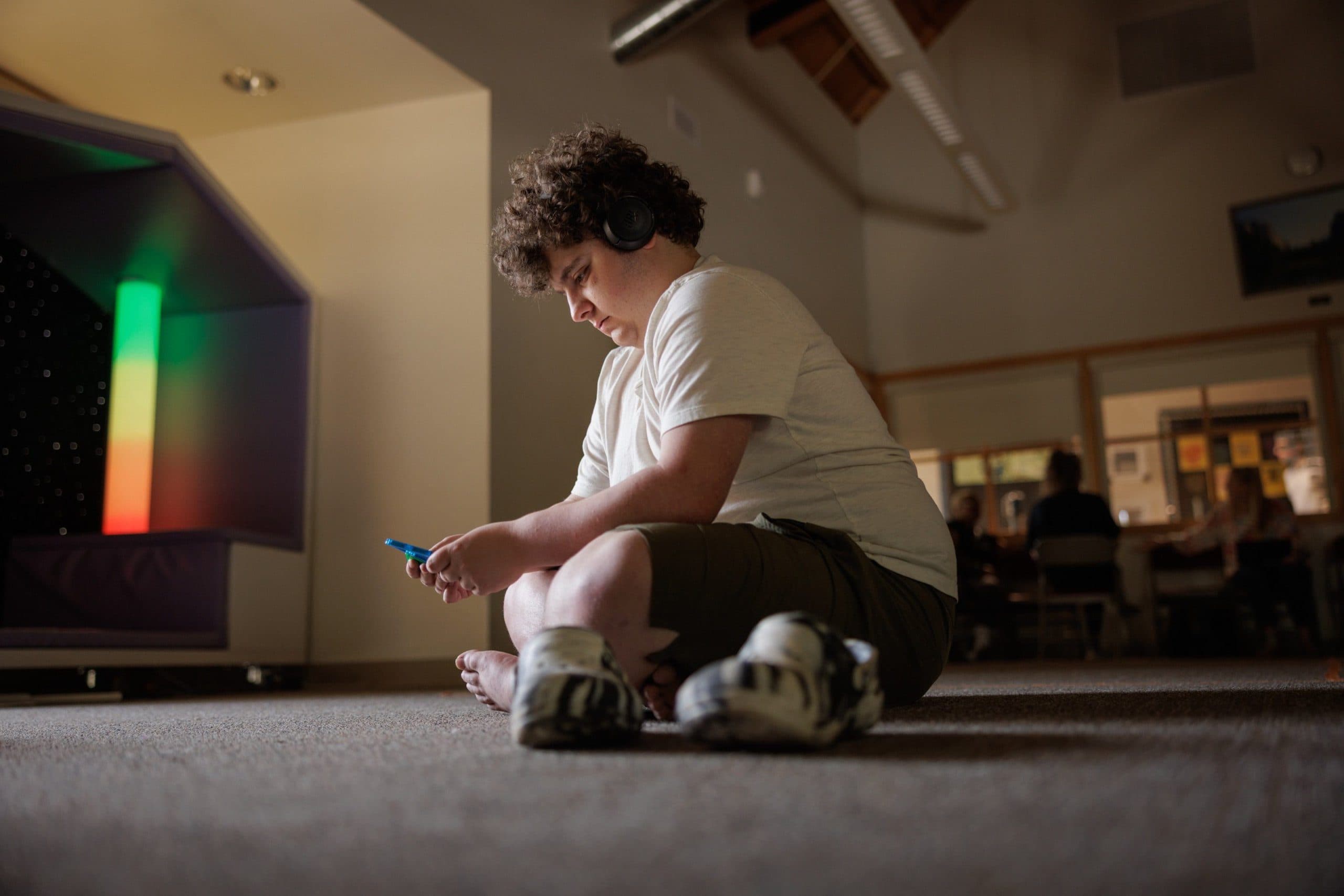 Student sitting near sensory lights in the sensory room