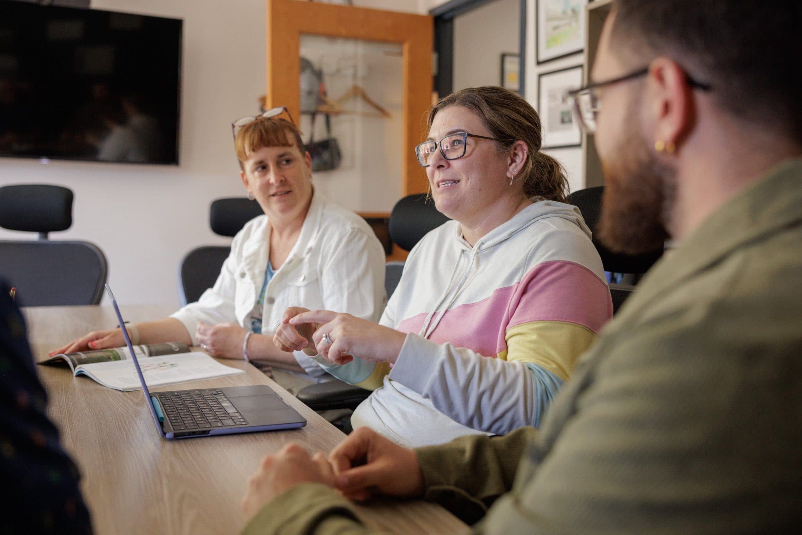 Staff members meeting around a table