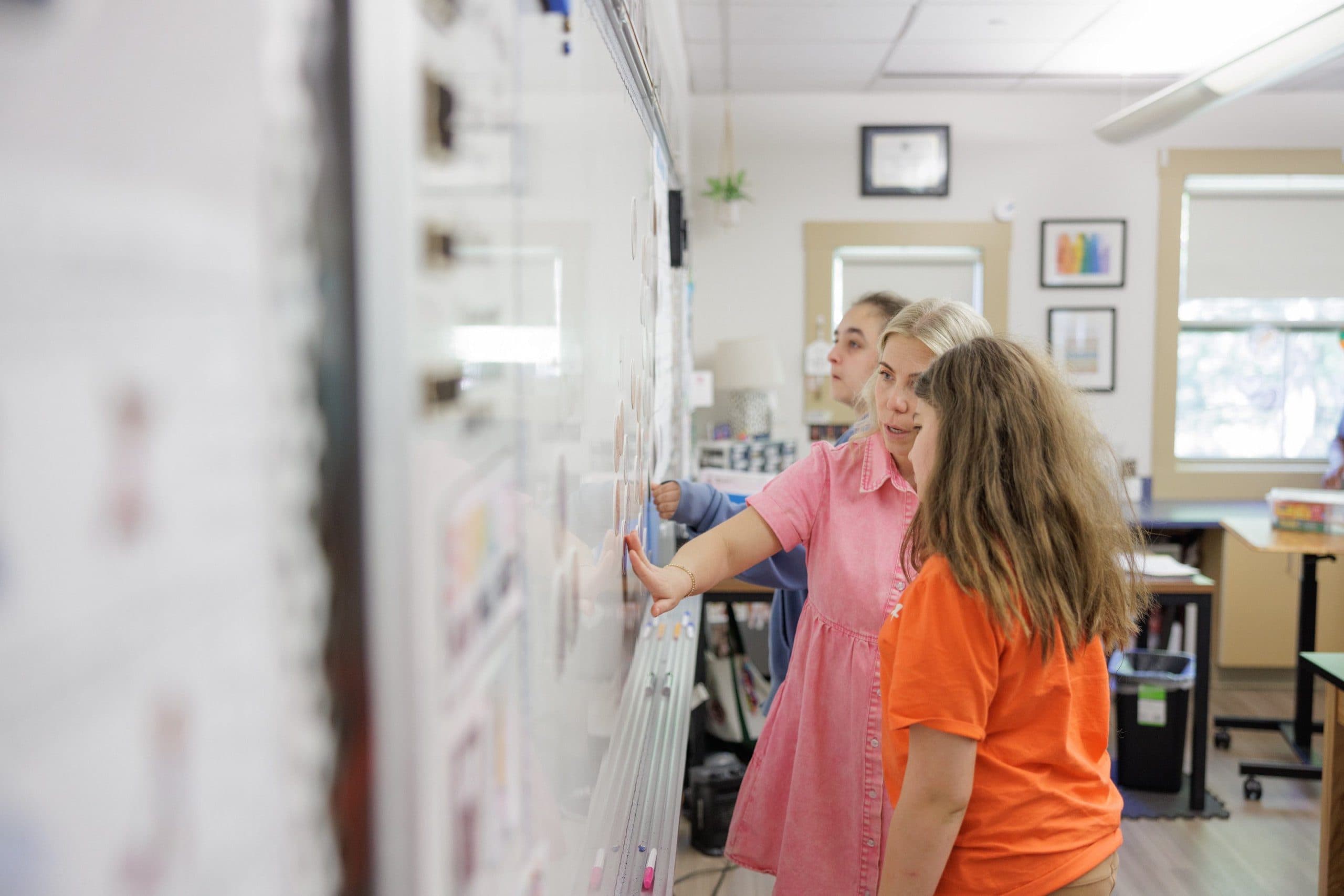 Teacher helping a student at the whiteboard