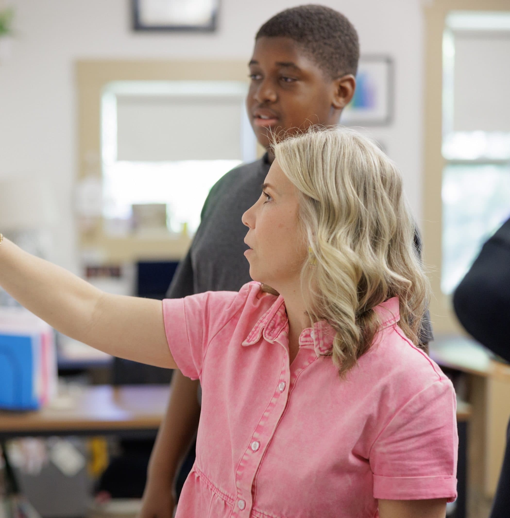 Teacher helping a student at the whiteboard
