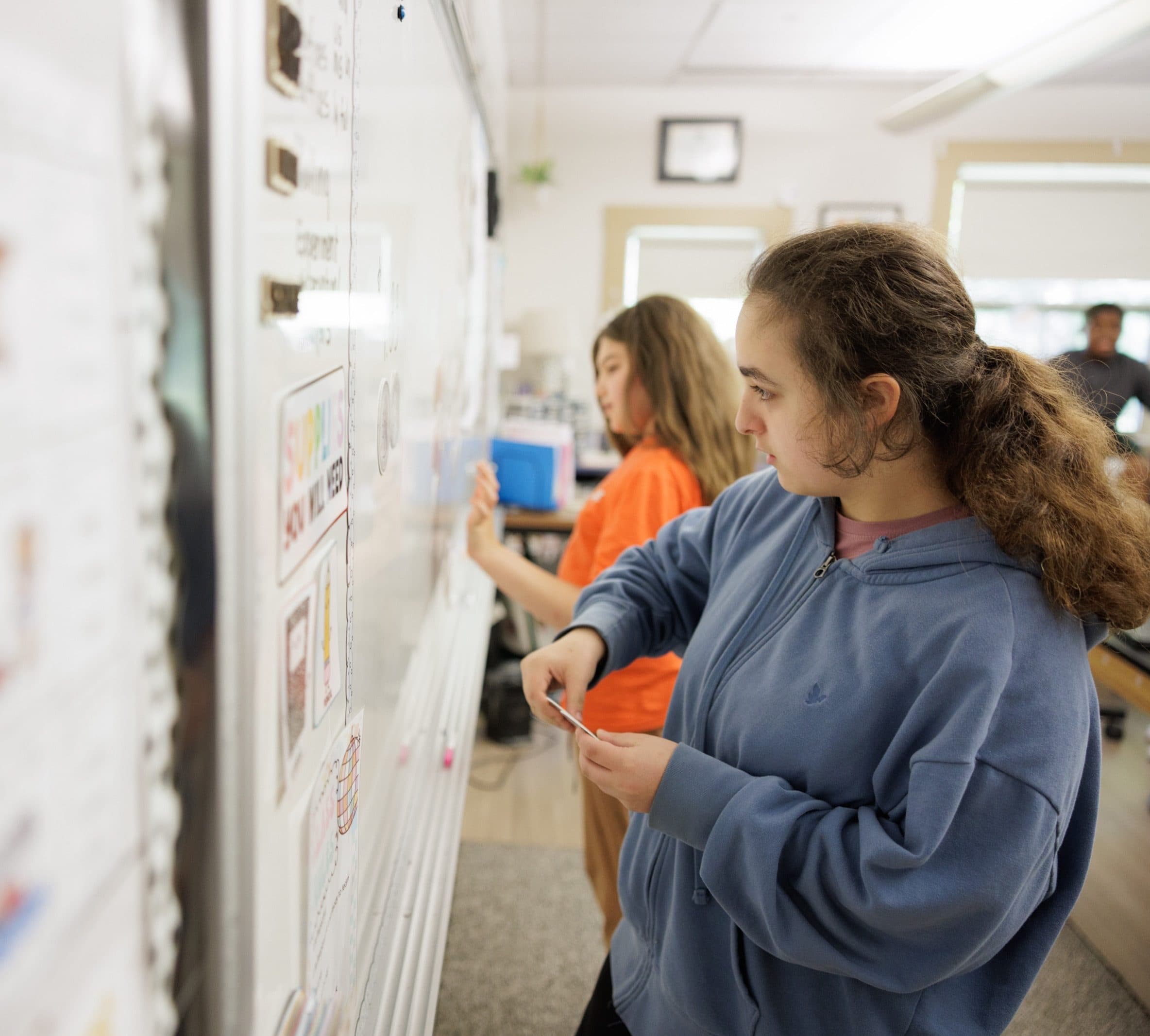 Two students working together at the whiteboard