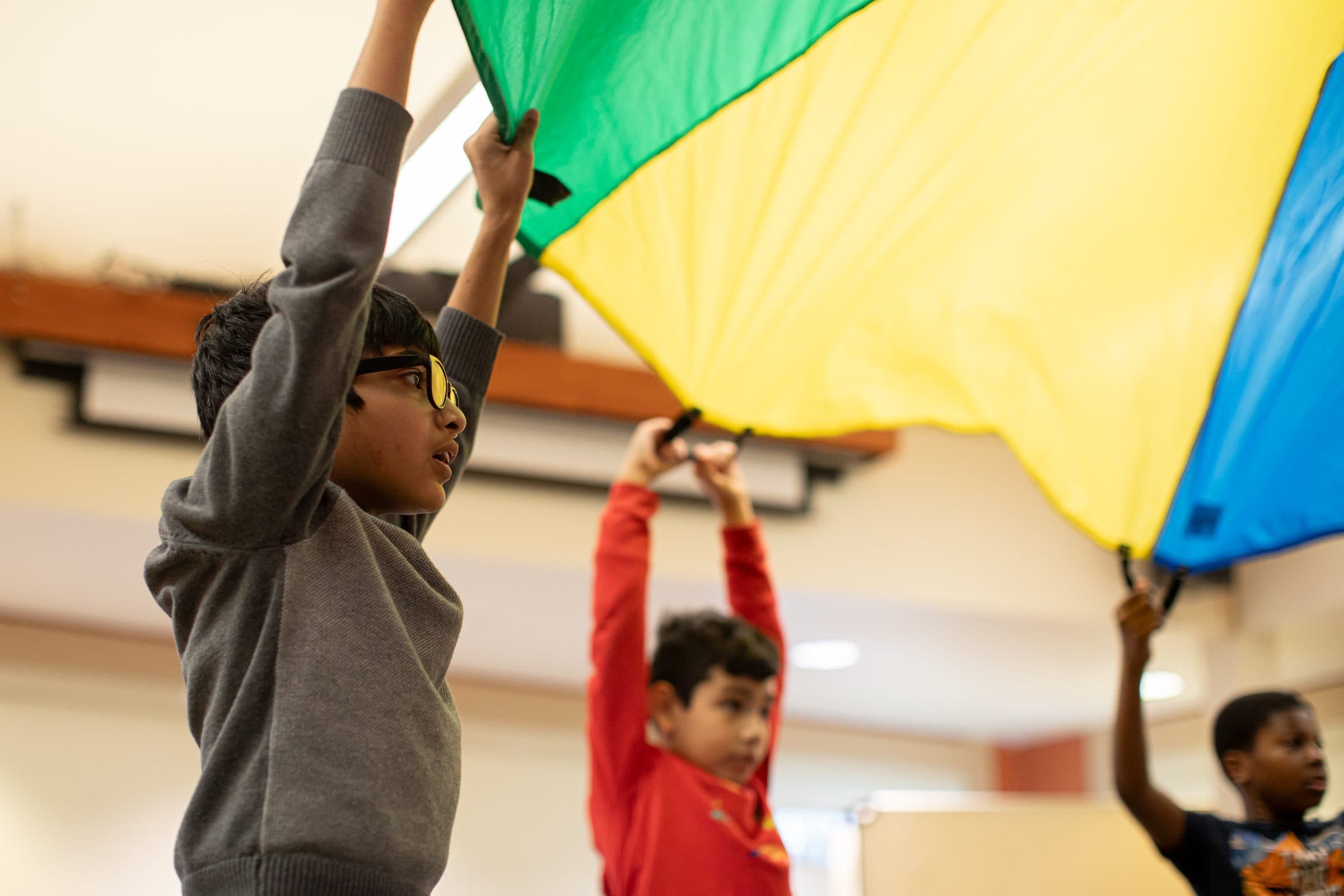 Students playing with a flag indoors