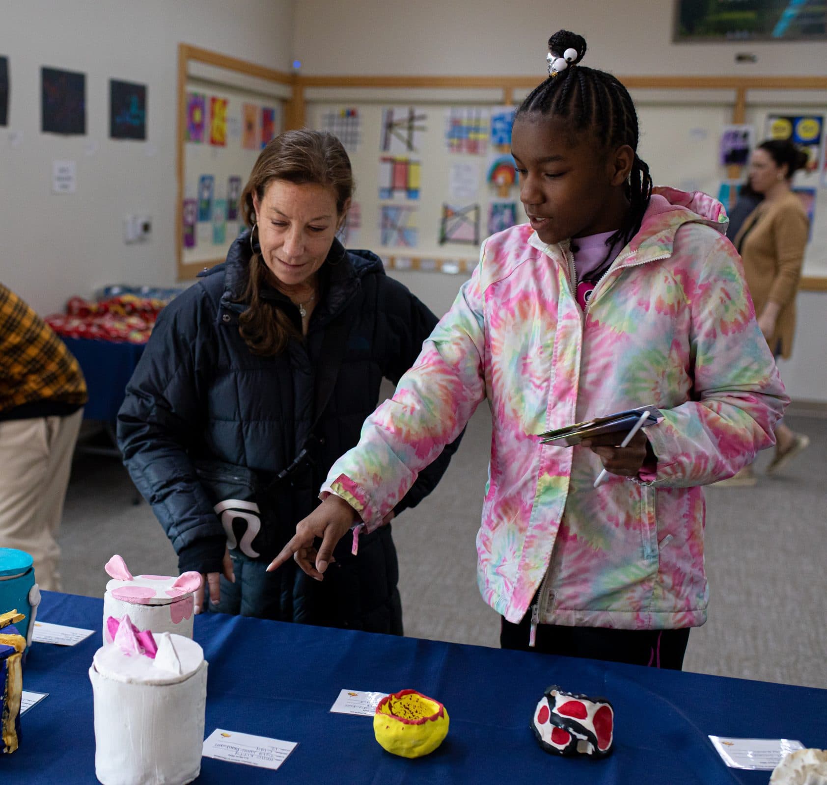 Teacher assisting a student in a decorated classroom