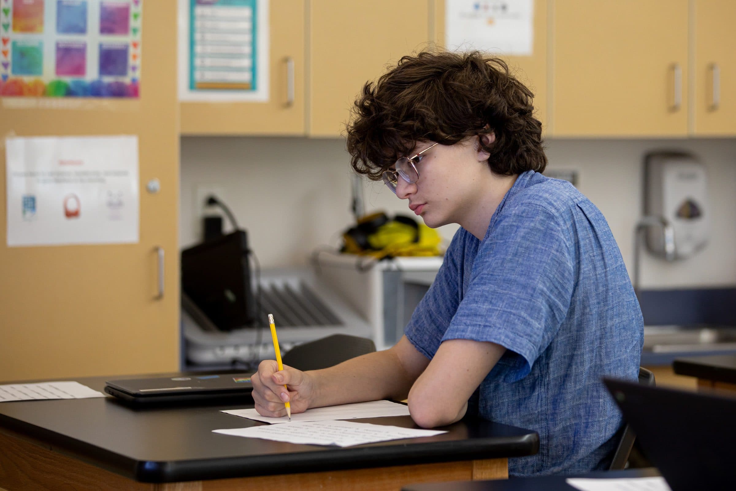 Student at desk, writing in notebook