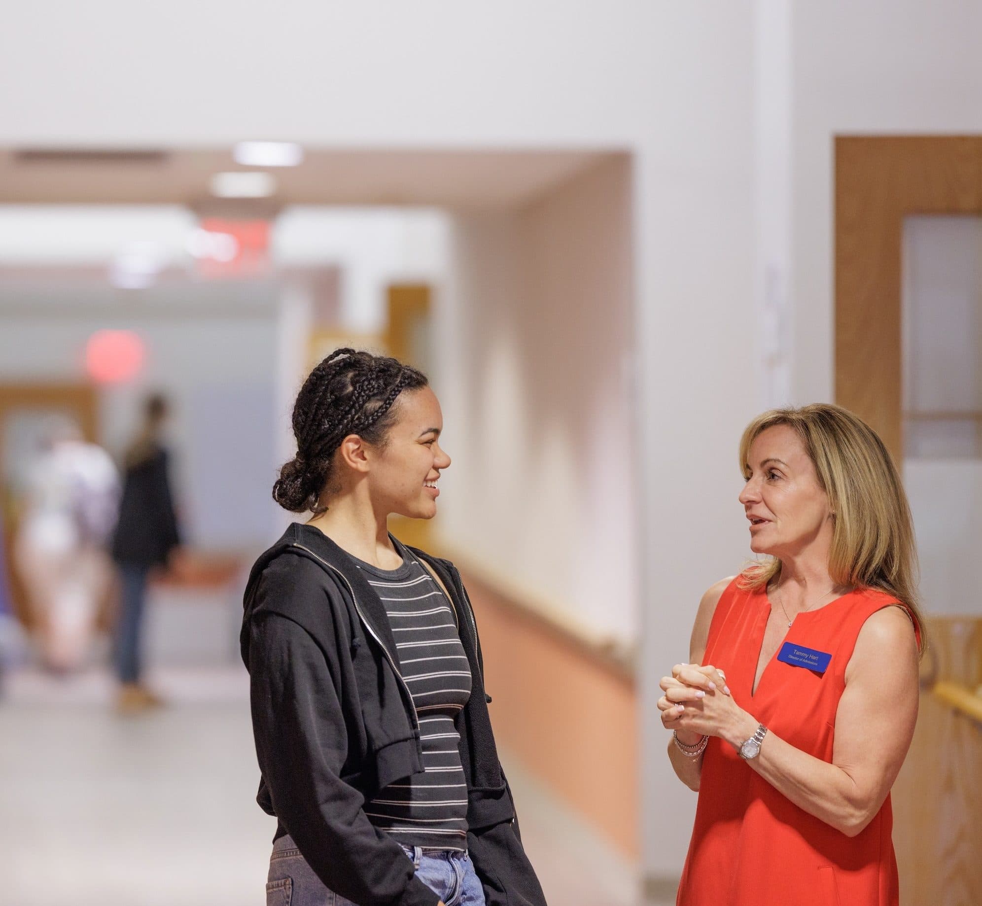 Student and staff member talking in the hallway