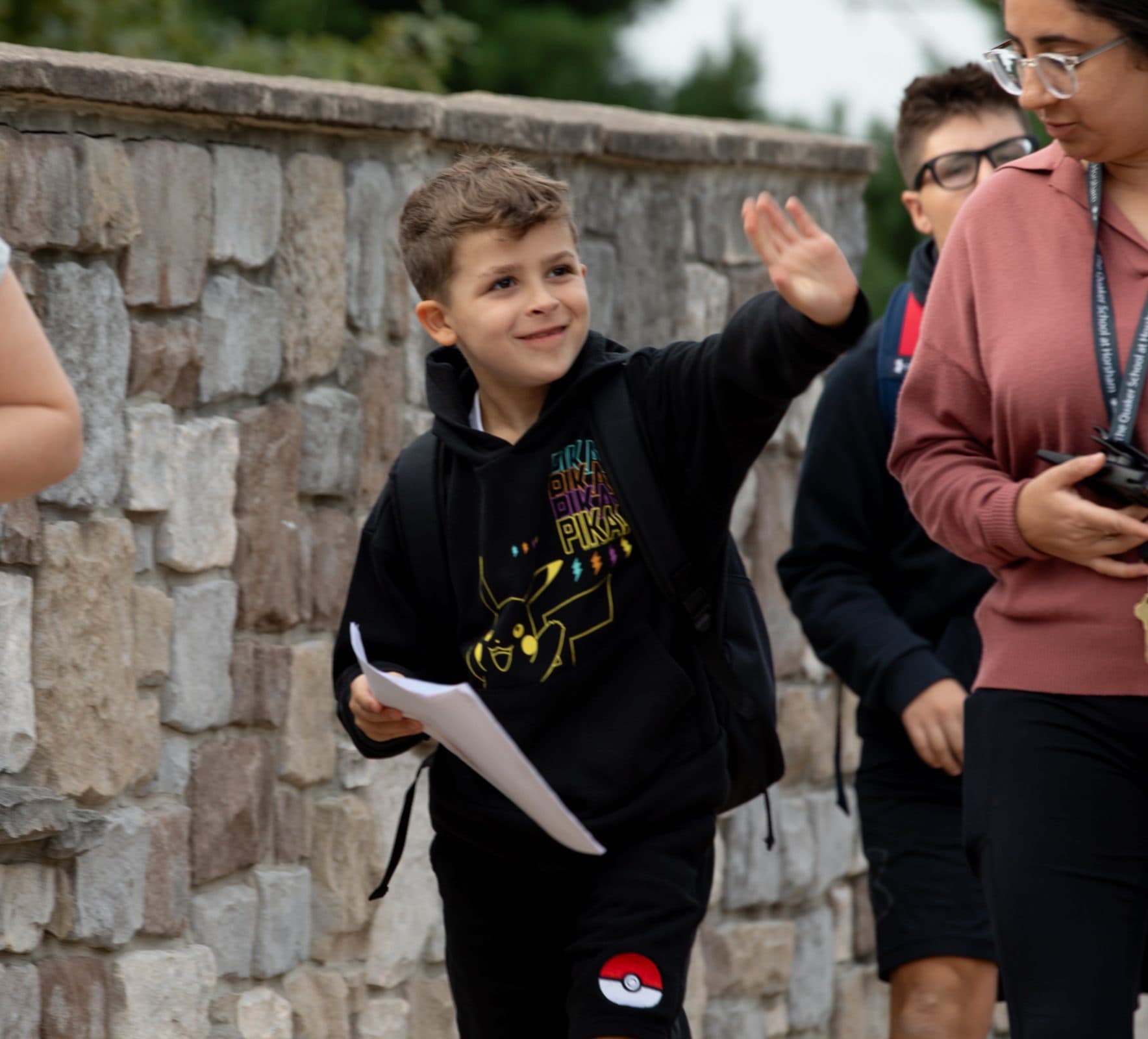 Students waving to each other outdoors