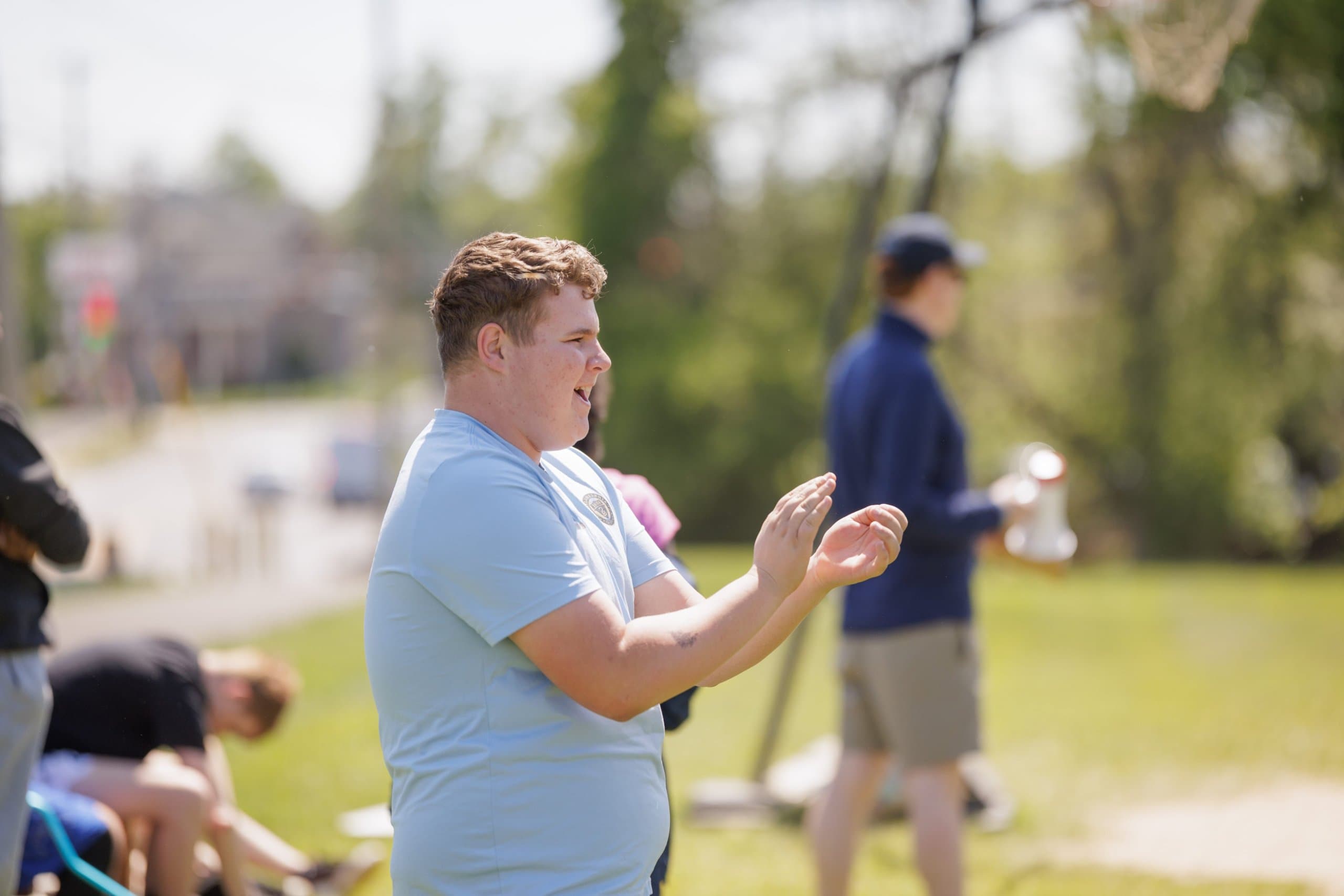 Student cheering on others outdoors
