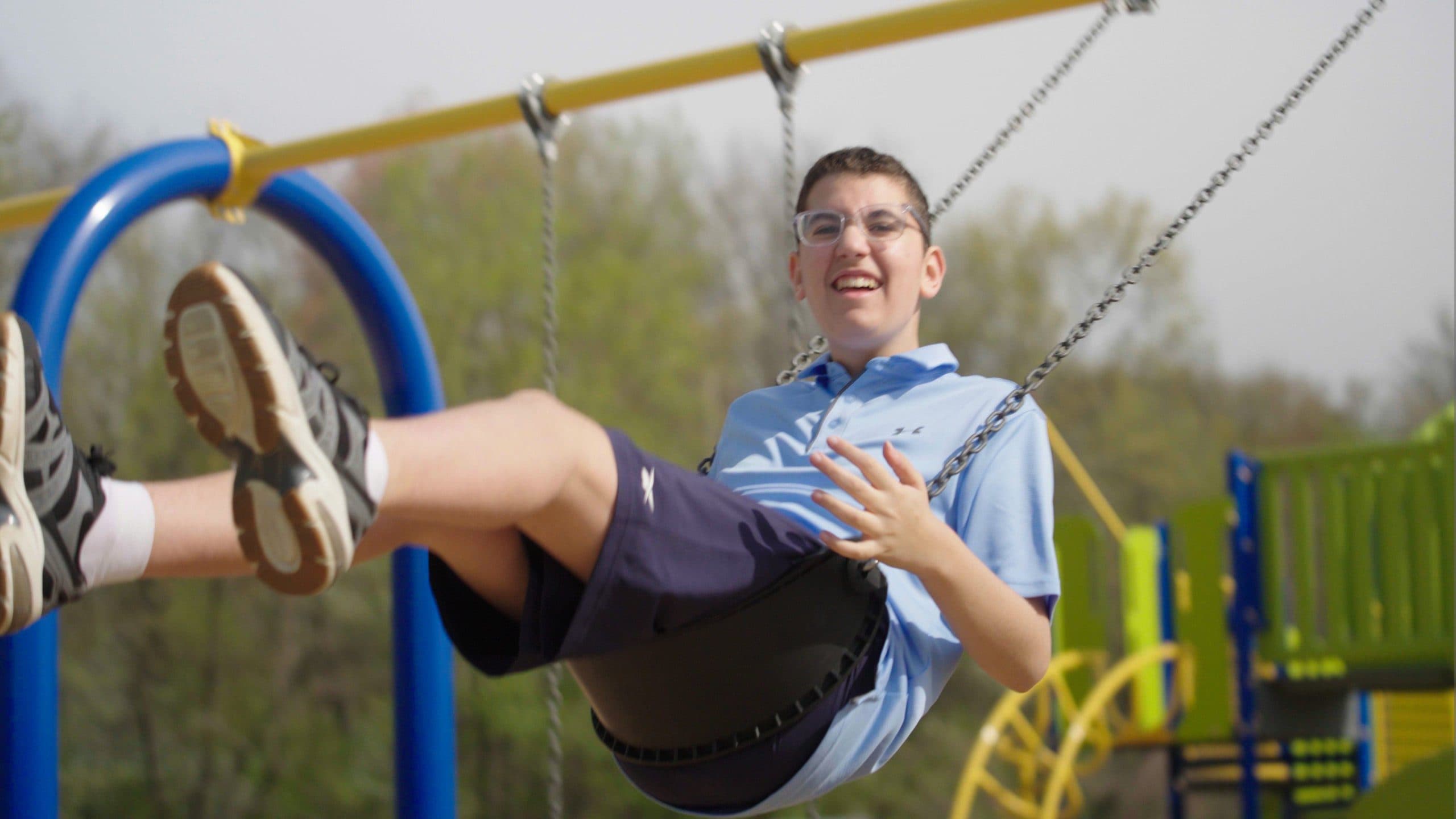 Student playing on outdoor swing