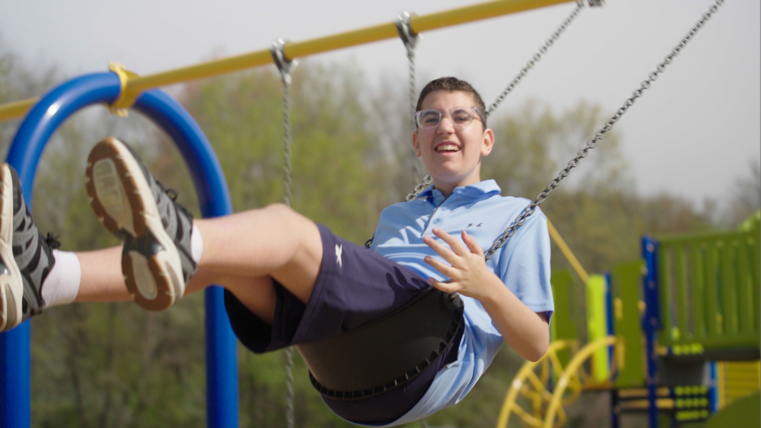 Student playing on outdoor swing