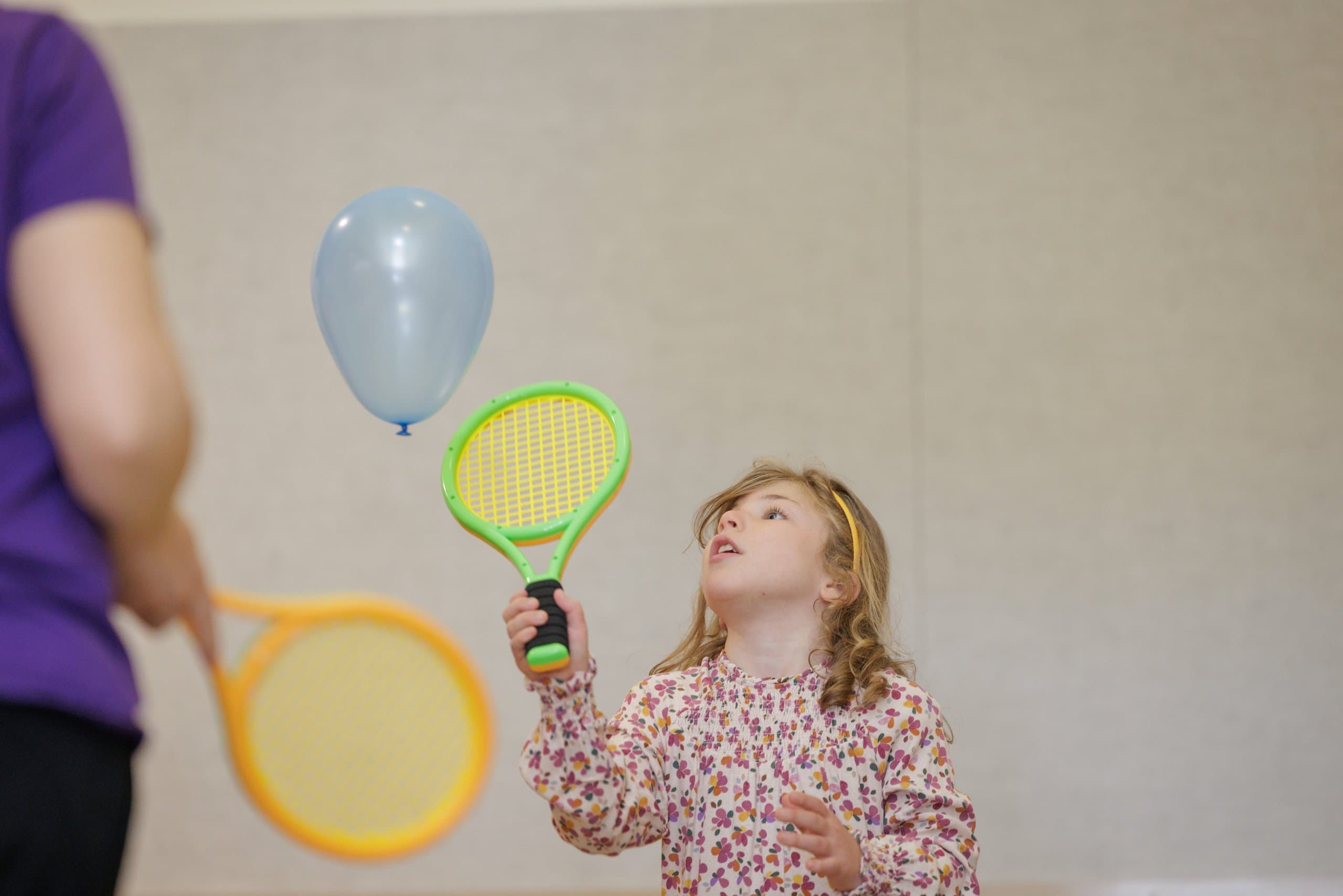 Student playing with a racket and balloon