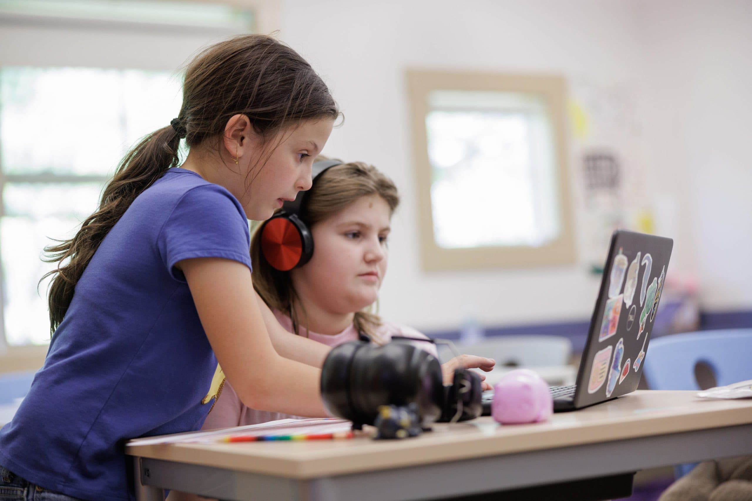 Two students working together at a laptop