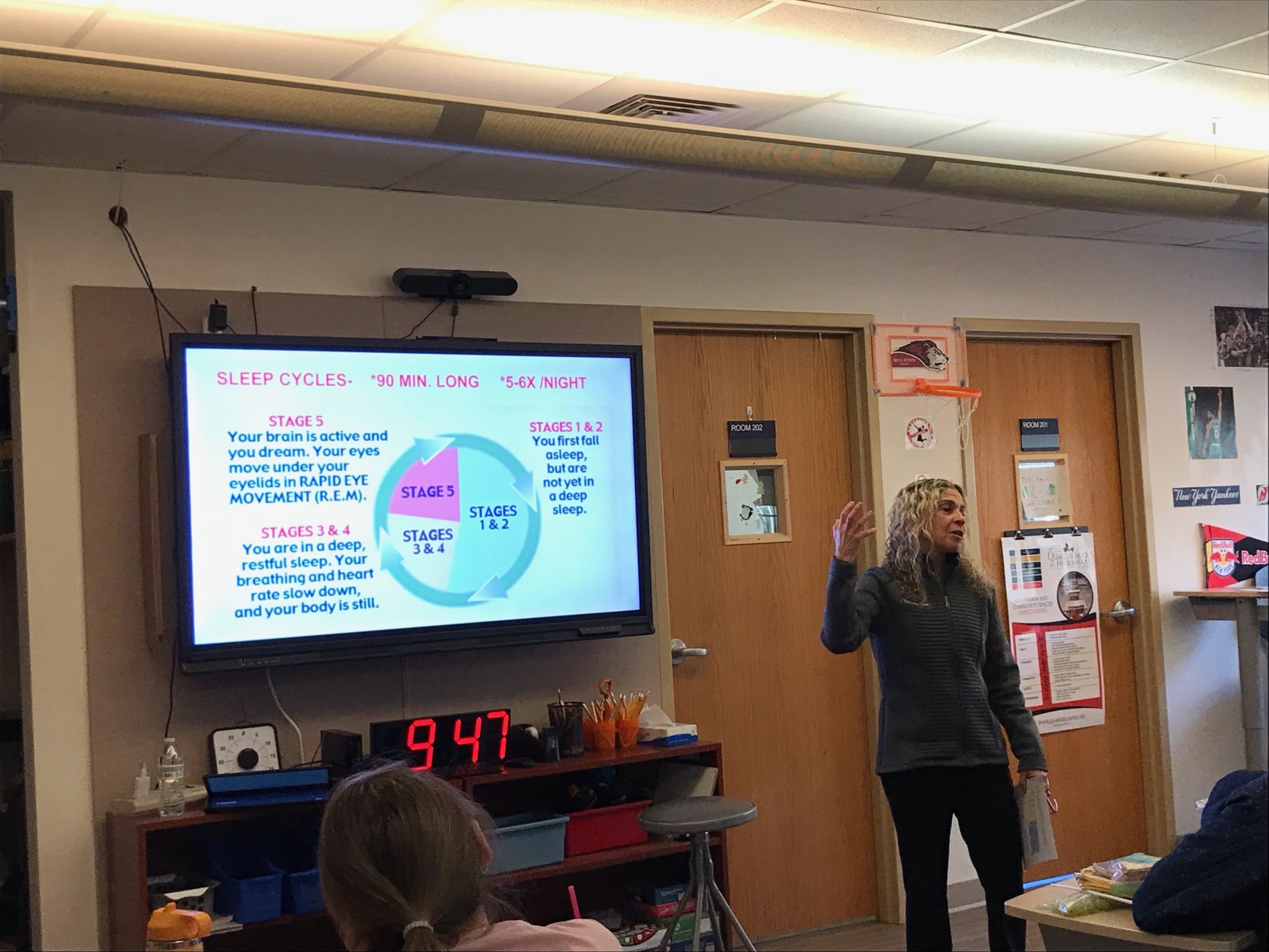 Staff member at a presentation with data displayed on screen