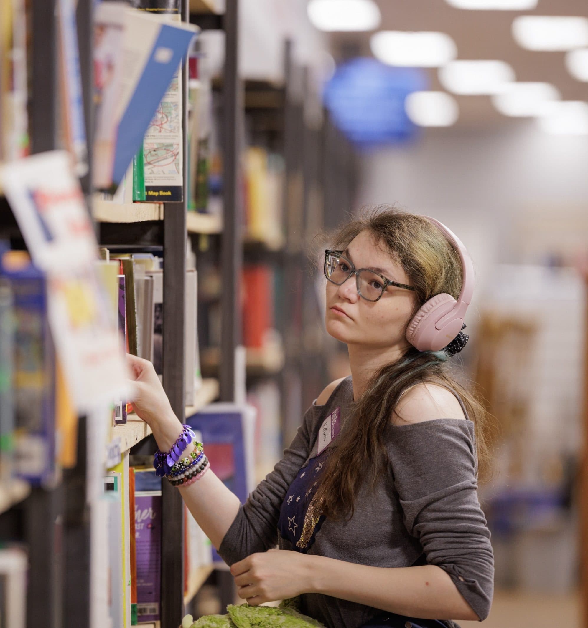 Student looking at books on a shelf
